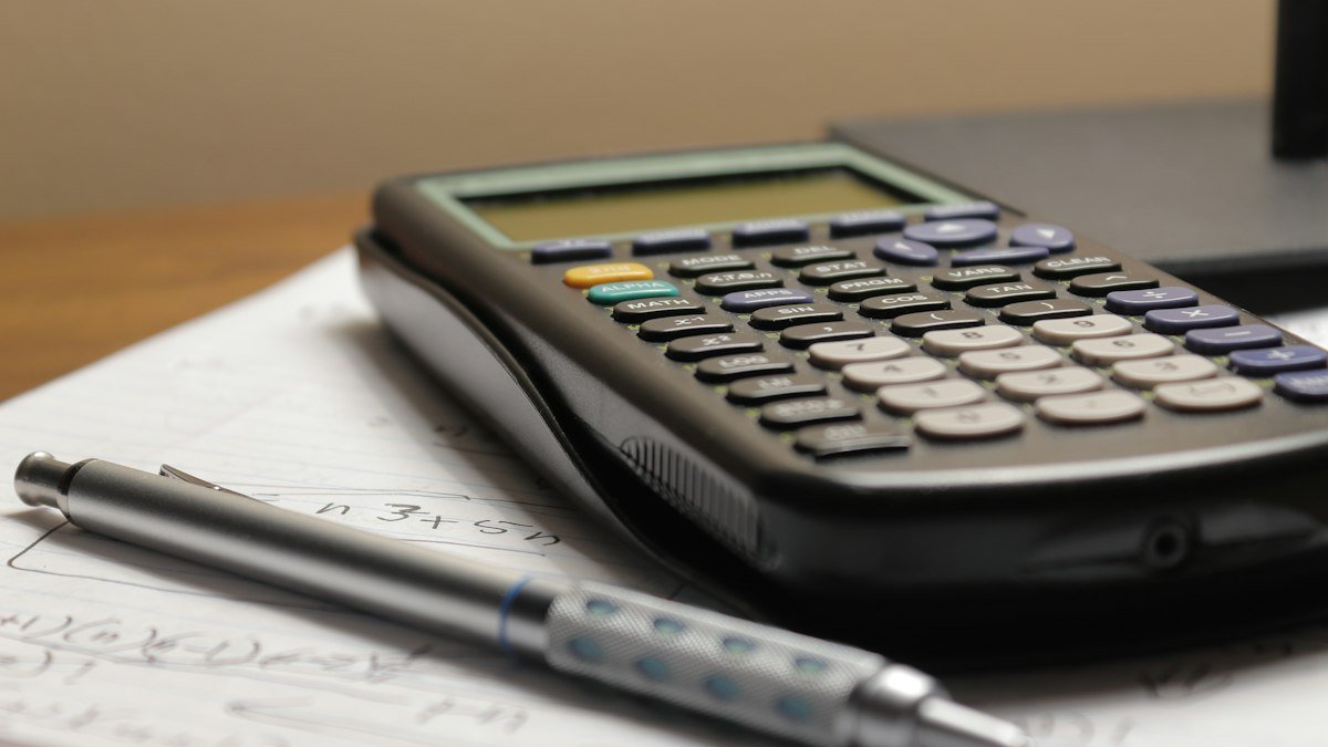 Papeles y calculadora sobre escritorio